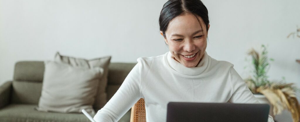 person smiling at laptop